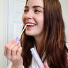 Kvinna i badrummet med Bleaching Glow Stick från Diamond Smile i handen