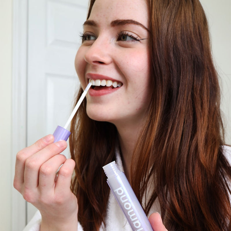 Kvinna i badrummet med Bleaching Glow Stick från Diamond Smile i handen