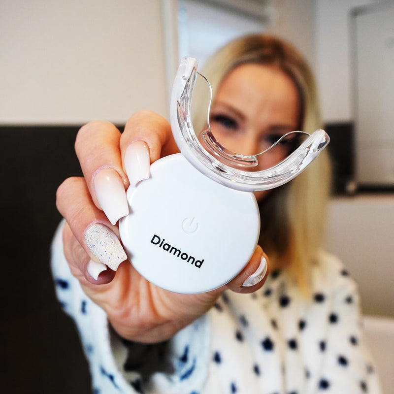 Kvinna med Diamond Smile lila färgkorrigerande tandblekningsset - lila blekningsset i handen