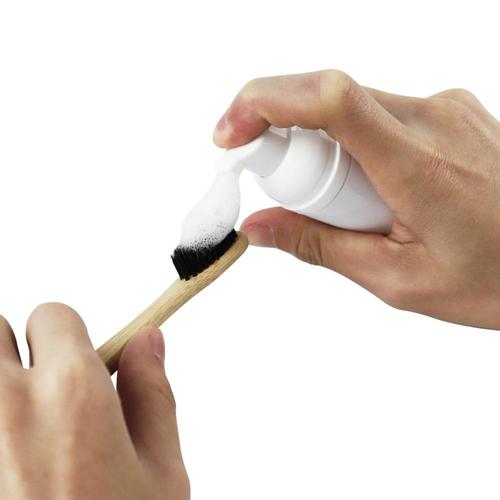 Tandborste med Diamond Smile tandblekningsskum mot en vit bakgrund